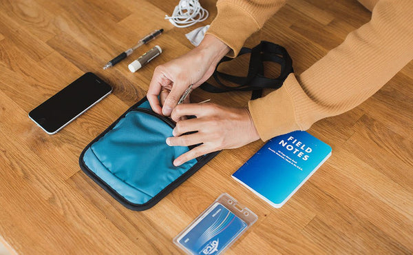 A sample loadout for a P.I.K.A. Pouch (a phone, pen, earbud headphones, chapstick, a pocket notepad, and a card holder).